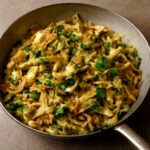 Seasoned cabbage cooked in a skillet on the stove