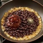 Chipotle black beans recipe served in a bowl with smoky sauce and herbs