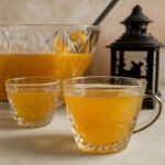 A glass pitcher of homemade fruit punch with citrus slices and ice
