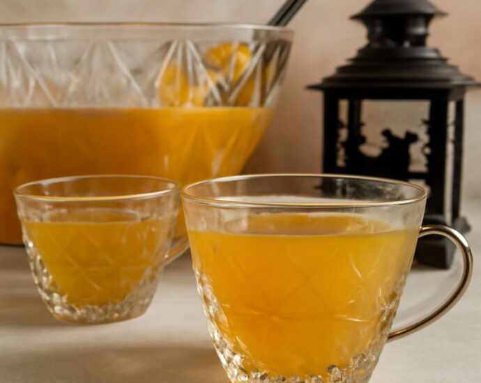 A glass pitcher of homemade fruit punch with citrus slices and ice