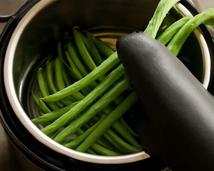Jarred green beans with canning tools and fresh beans