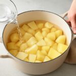 Make-ahead mashed potatoes in a serving bowl with butter on top