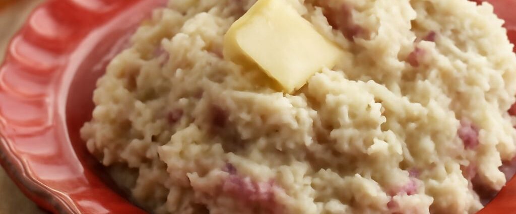 Creamy mashed red potatoes in a bowl with herbs
