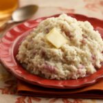 Creamy mashed red potatoes in a bowl with herbs