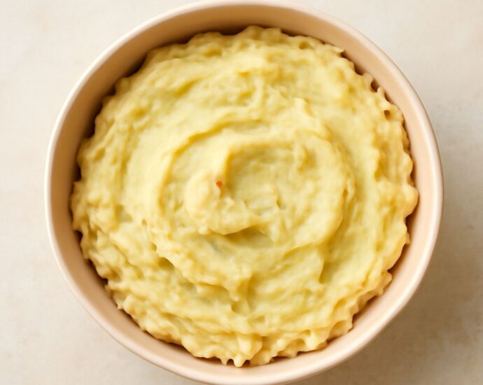 Mashed potatoes reheating in the oven in a covered baking dish