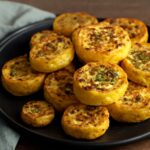 Roasted yellow squash on a baking sheet with olive oil and seasoning