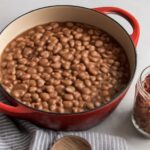 Dry pinto beans soaking in water in a bowl