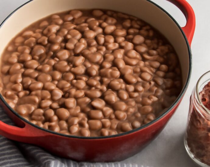 Dry pinto beans soaking in water in a bowl