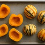 Roasted sweet dumpling squash with seasoning on a baking sheet