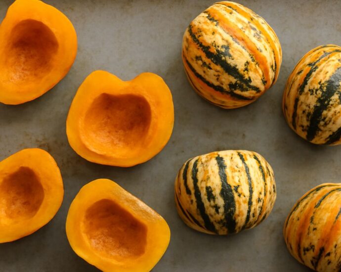 Roasted sweet dumpling squash with seasoning on a baking sheet
