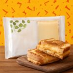 Assorted vegan cheese brands sliced and served on a board