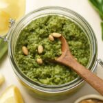 Vegan pesto in a bowl with basil, nuts, and olive oil