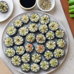 Vegan sushi rolls with rice, nori, avocado, cucumber, and carrots
