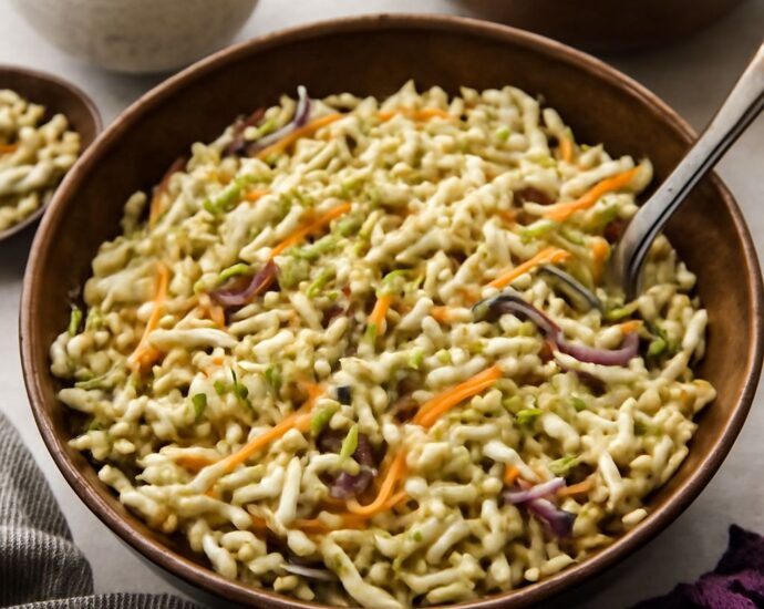 Broccoli slaw with ramen noodles, sunflower seeds, and tangy dressing in a serving bowl