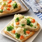 Chilled crescent-roll vegetable pizza squares topped with finely chopped broccoli, carrots, and bell pepper