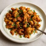 Browned cauliflower florets with a toasted curry coating on a sheet pan
