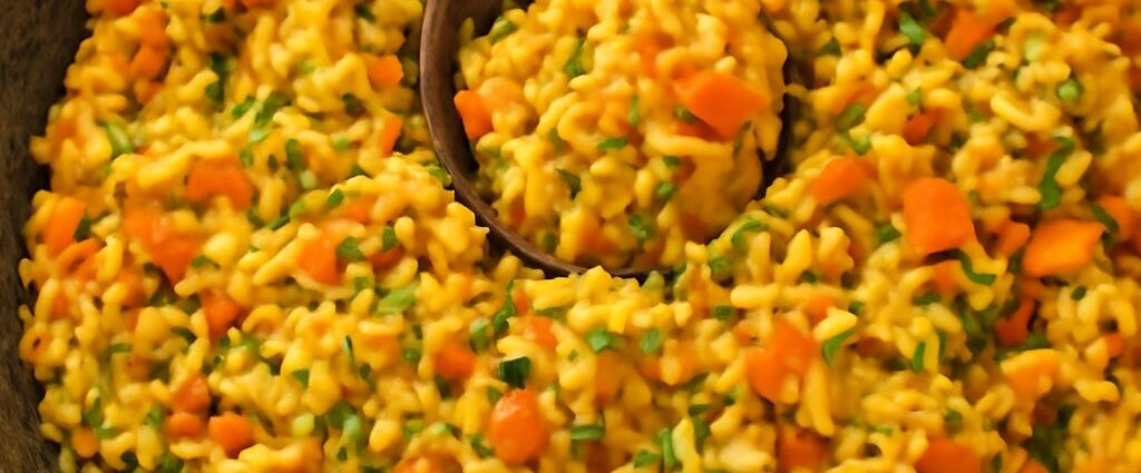 A bowl of fluffy basmati rice colored golden by bloomed spices