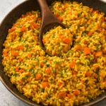 A bowl of fluffy basmati rice colored golden by bloomed spices
