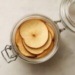 Apple slices drying on a dehydrator tray until chewy or crisp