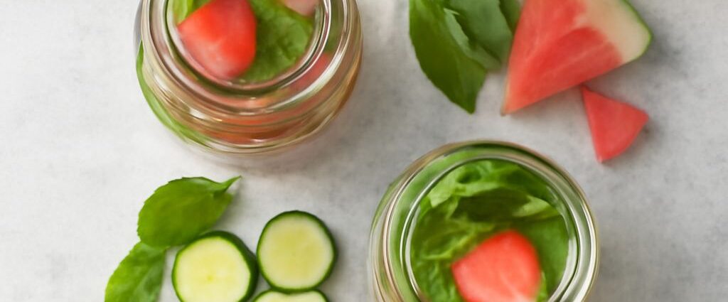 Pitcher of fruit-infused water with citrus, berries, cucumber, and herbs