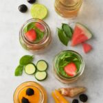Pitcher of fruit-infused water with citrus, berries, cucumber, and herbs