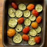 Oven roasted zucchini and yellow squash with browned edges on a sheet pan