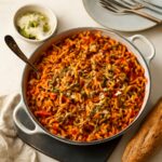 Pesto tomato sauce served over pasta with basil