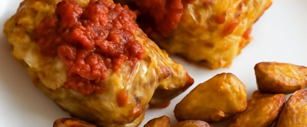 Vegetarian Polish stuffed cabbage rolls filled with mushrooms, grains, and lentils in tomato sauce