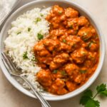 A rice bowl recipe with warm rice, cooked vegetables, fresh toppings, and sauce