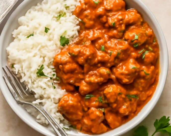 A rice bowl recipe with warm rice, cooked vegetables, fresh toppings, and sauce