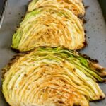 Browned and tender roasted cabbage wedges on a sheet pan