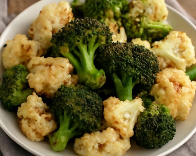 Roasted broccoli and cauliflower florets with tender centers and browned edges on a sheet pan