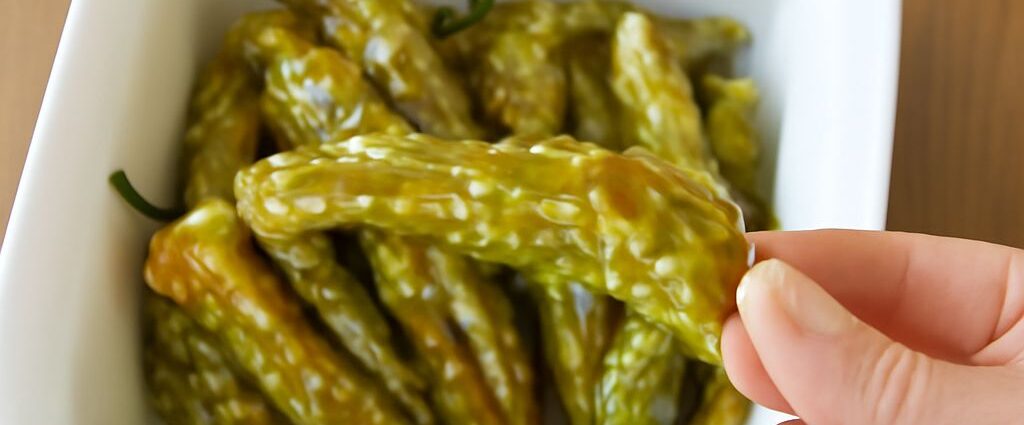Blistered oven-roasted shishito peppers on a serving plate