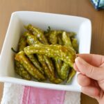 Blistered oven-roasted shishito peppers on a serving plate