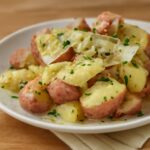 A tray of crisp-golden smashed red potatoes with creamy centers