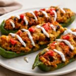 Vegetarian stuffed Anaheim peppers filled with rice, beans, tomato sauce, and vegan cheese
