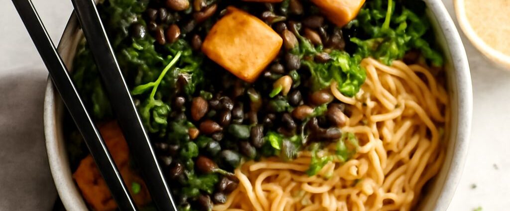 Vegetarian tofu ramen bowl topped with browned tofu, noodles, greens, and sesame