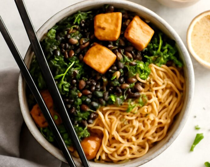 Vegetarian tofu ramen bowl topped with browned tofu, noodles, greens, and sesame