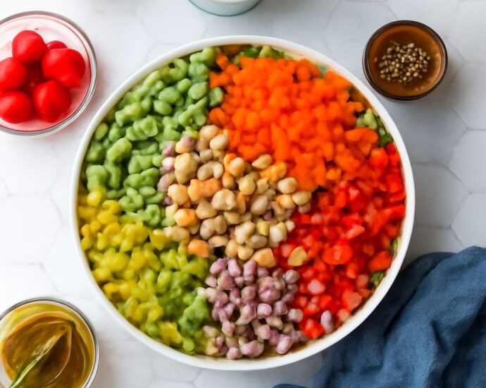 Vegan salad recipe with quinoa, chickpeas, greens, vegetables, and tahini dressing