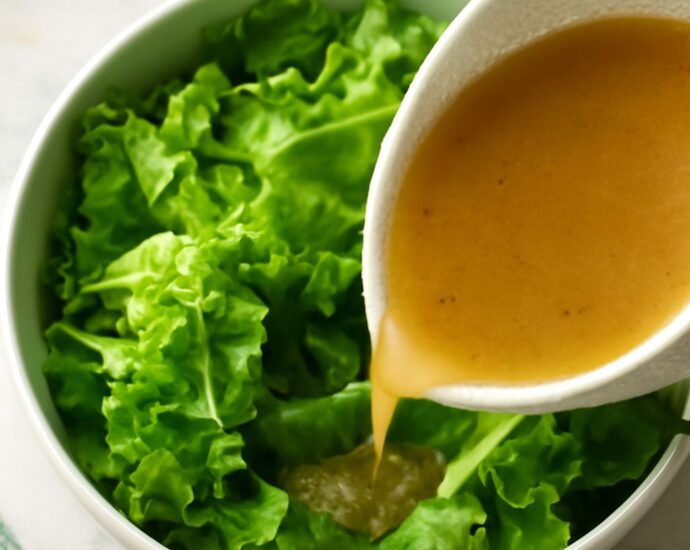Tender-crisp lettuce salad with glossy leaves and warm sweet-tangy dressing