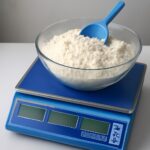 Measuring cup filled with flour on a scale