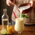 A refreshing homemade pina colada served in a glass with a pineapple slice garnish.