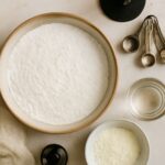 Bowl of royal icing with meringue powder and decorated sugar cookies