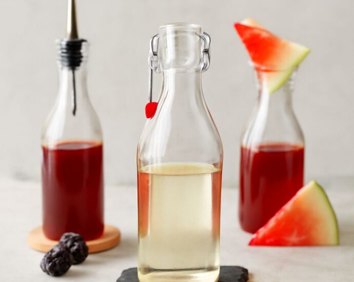 A jar of simple syrup with a spoon and ingredients for making simple syrup.